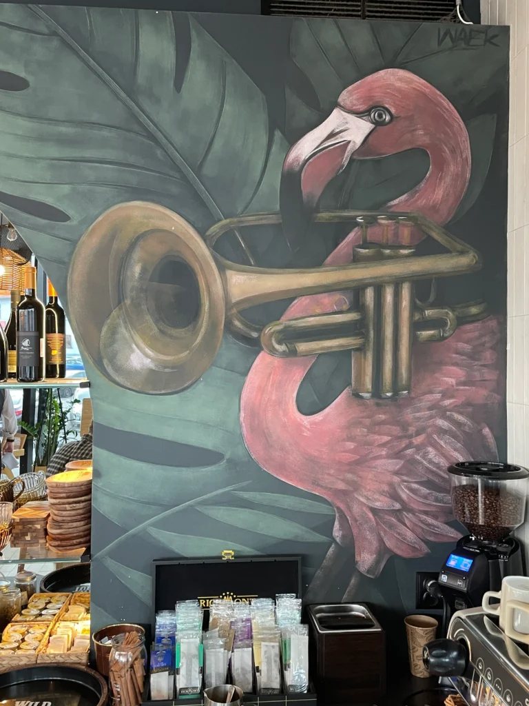 Mural na zlecenie restauracji Melomania przy filharmonii Zielonogórskiej przestawiajacy flamingi z instrumentami muzycznymi